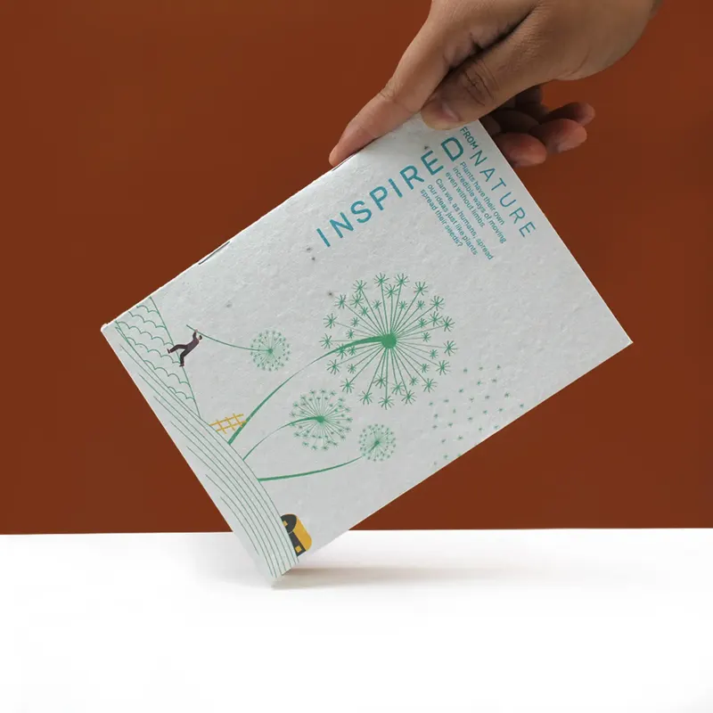 A seed-paper plantable notepad held in one hand