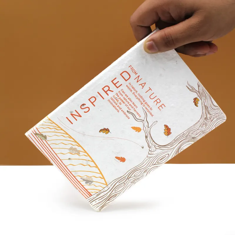 Hand holding a perfect-bound plantable seed-paper diary