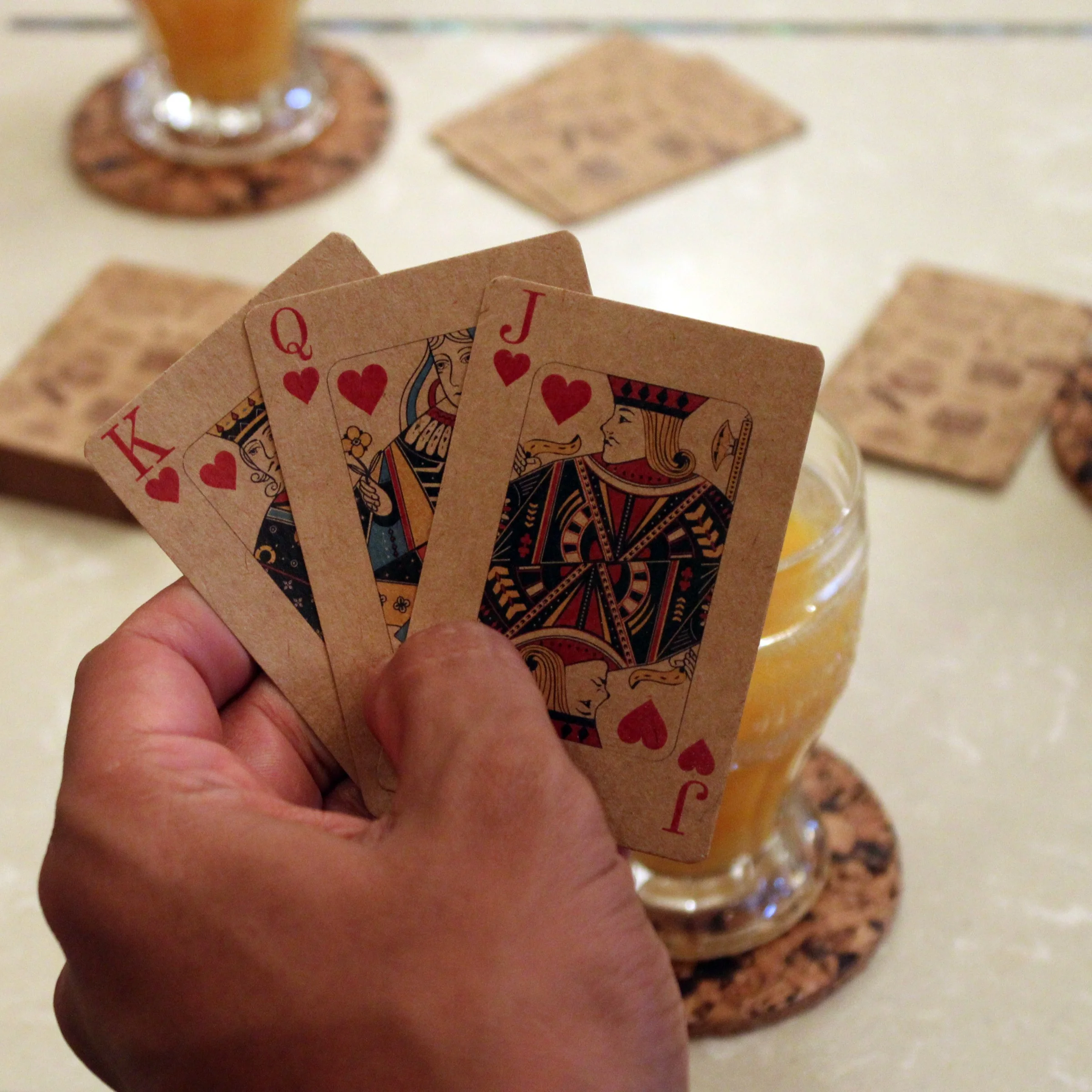 D10 kraft playing cards held in a hand to show the printed card faces