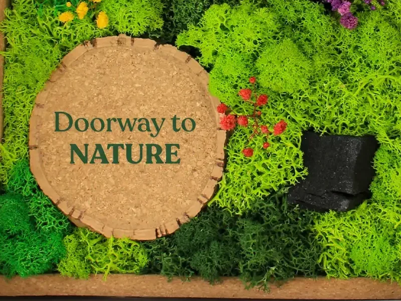 Close-up of the cork circle on the moss frame, printed with a sample message, among preserved moss and small flowers