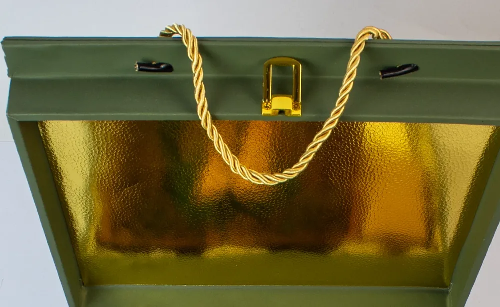 Inside the open lid of the Emerald Forest Chest: gold foil, a brass clasp and a twisted gold rope handle