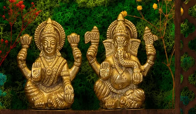 Close-up of the brass Laxmi and Ganesh idols against preserved moss