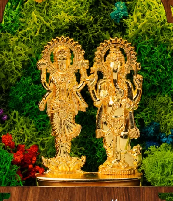 Close-up of the two slim gold-tone idols and the preserved flowers around them