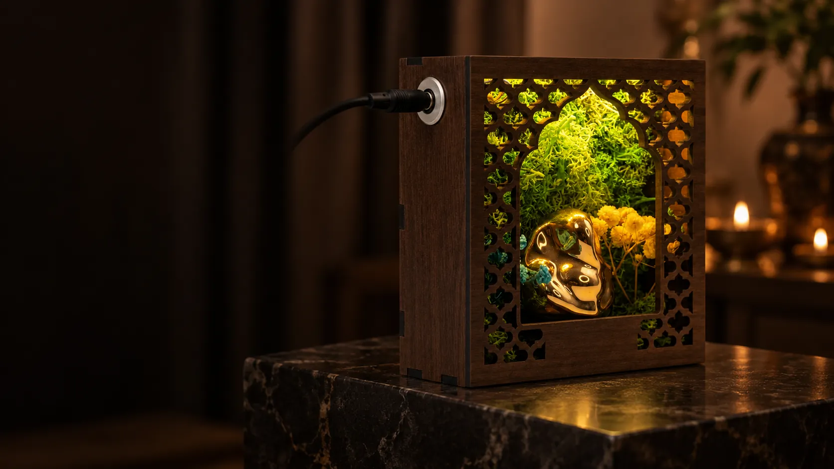 Forest Namah lit Ganesha, 5 inch: a small lit walnut-coloured frame with a lattice arch, moss and a golden ceramic Ganesha, on a dark stone block in a dim room with candle flames behind. A digitally styled view.