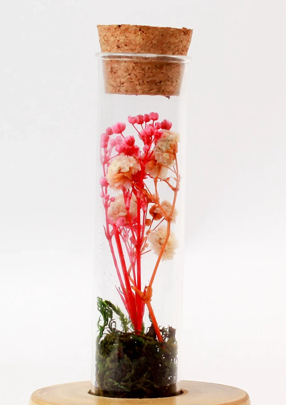 Close view of the cork stopper and preserved pink and peach flowers inside the Forest Stump Tall glass bottle
