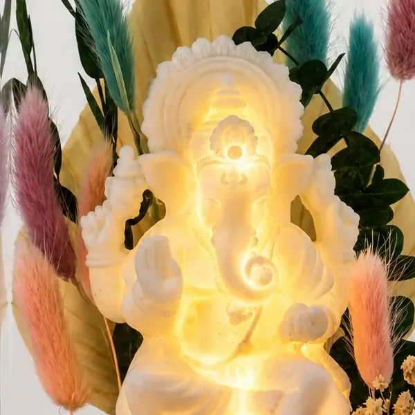 Close-up of the glowing white Ganesha among preserved grasses and leaves