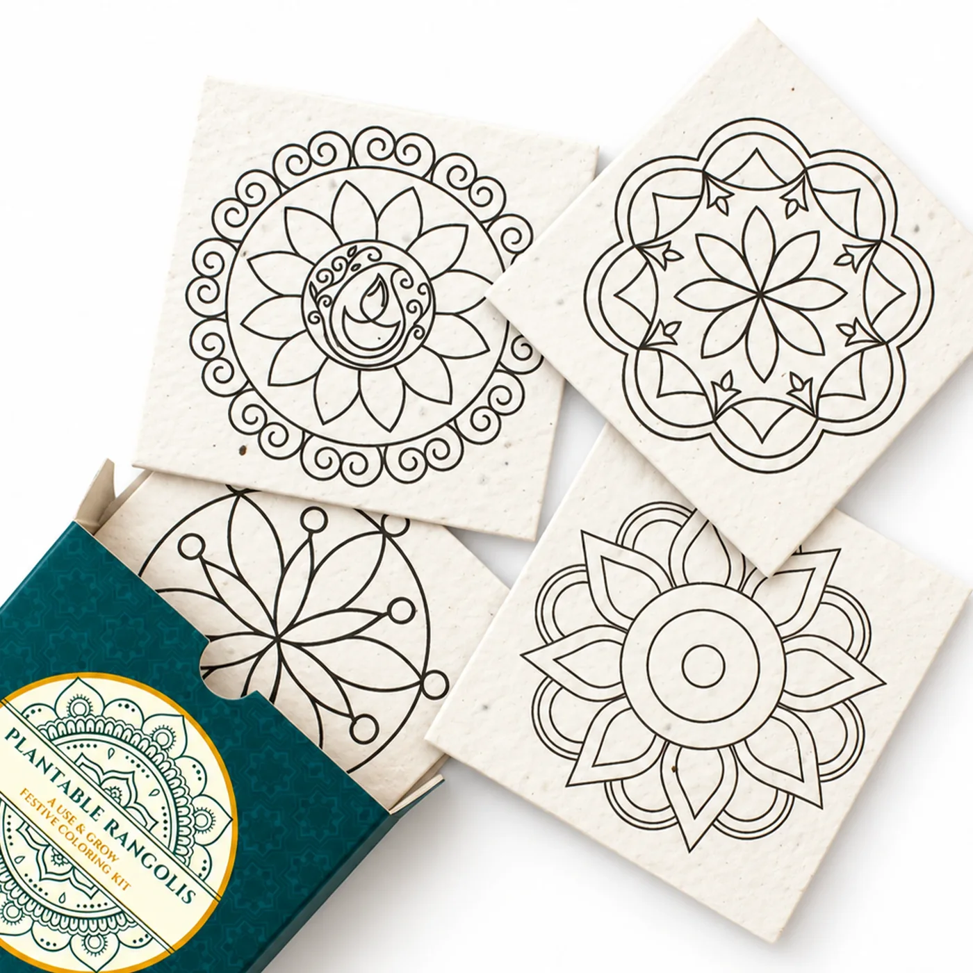 The four BG-Rangoli seed-paper rangoli cards spilling from their teal box