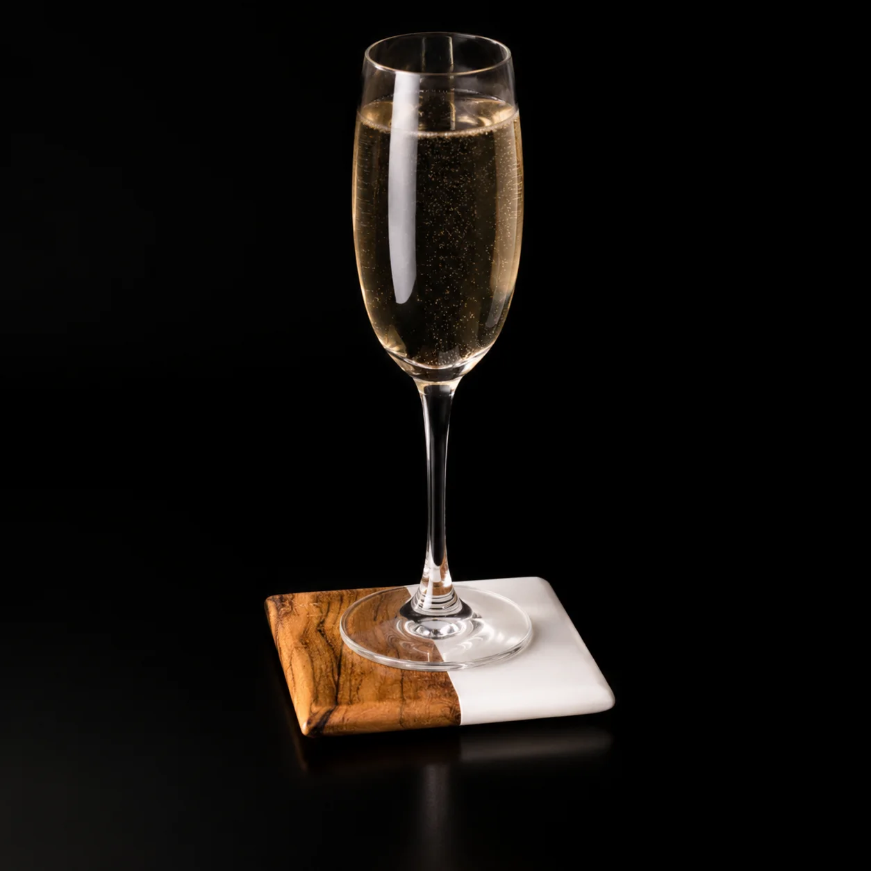 One square marble and wood coaster in use beneath a glass