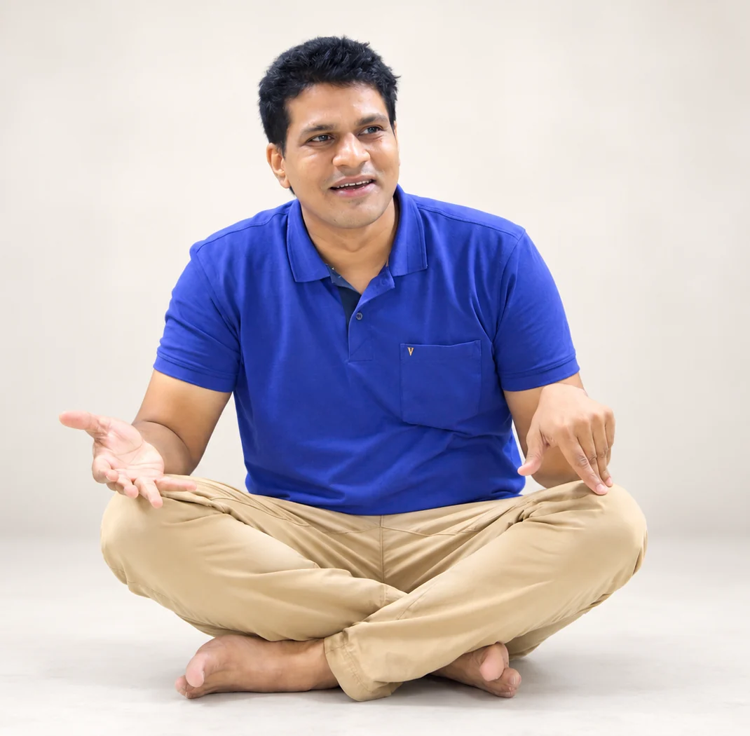 Saurabh Mehta, founder of bioQ, sitting cross-legged on the floor and talking with both hands, in a blue shirt