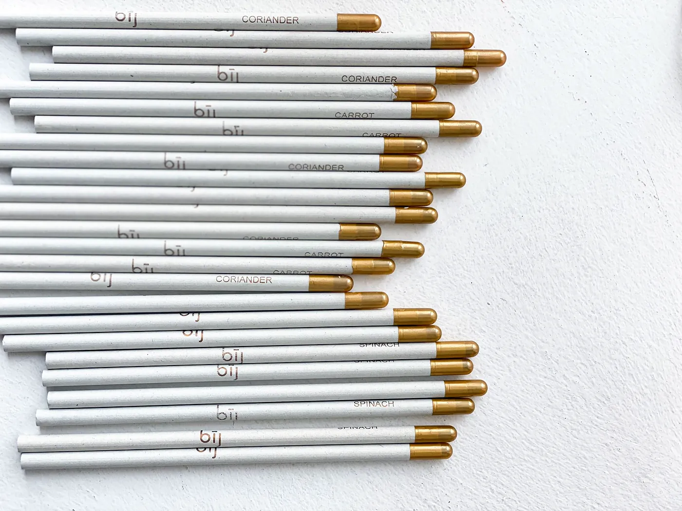 bīj pencils laid on a marble surface with the kraft card