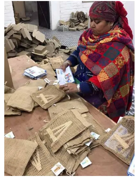 A woman packing calendar sets into jute bags