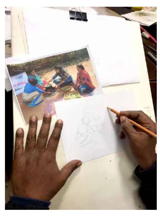A hand sketching the scene in pencil beside the photograph