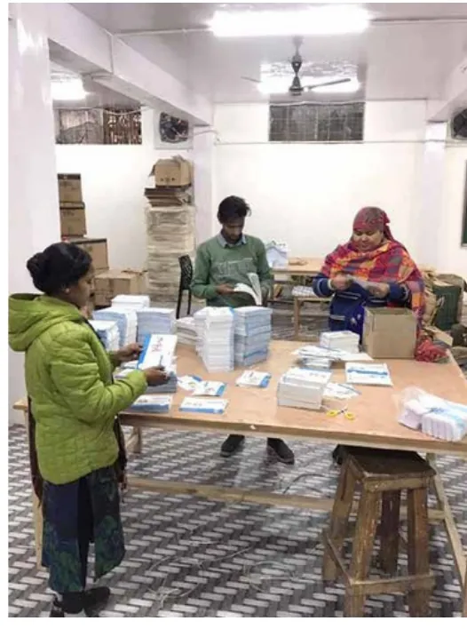 Three people sorting calendar sets on a table
