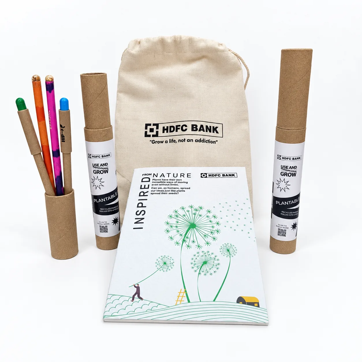 A cotton drawstring bag printed with the client’s name, a seed-paper notepad, and two kraft tubes of plantable pens and pencils
