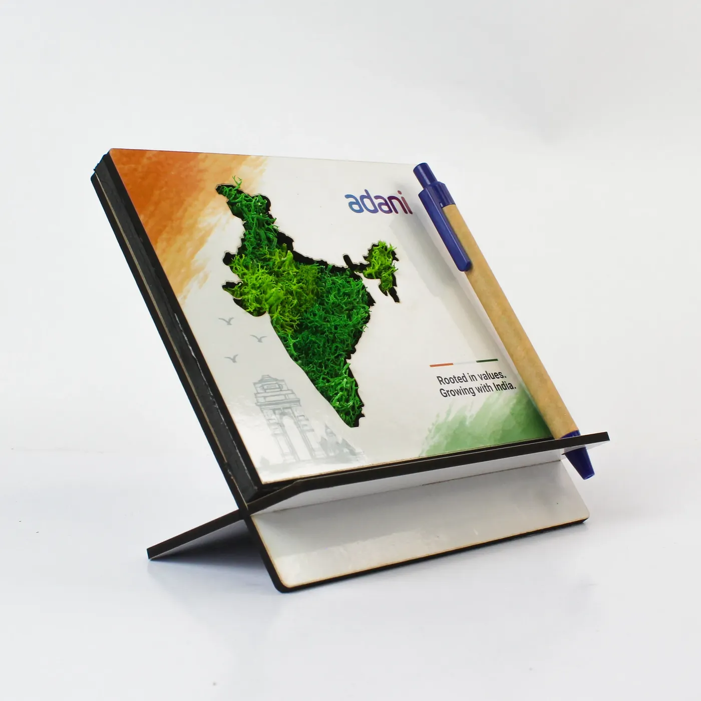 A pen stand with a map of India in preserved moss and the Adani mark