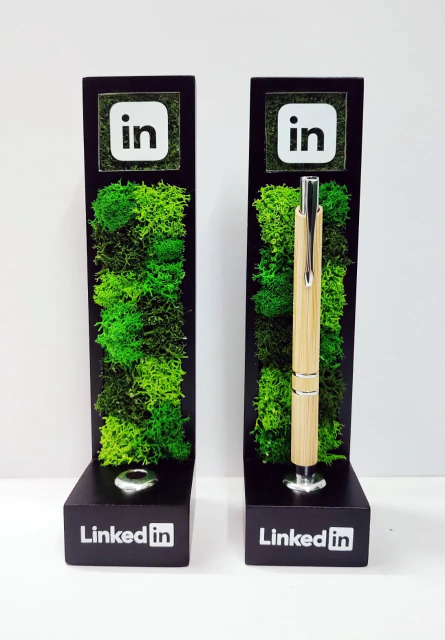 Two black pen stands, each with a column of moss and the mark on top