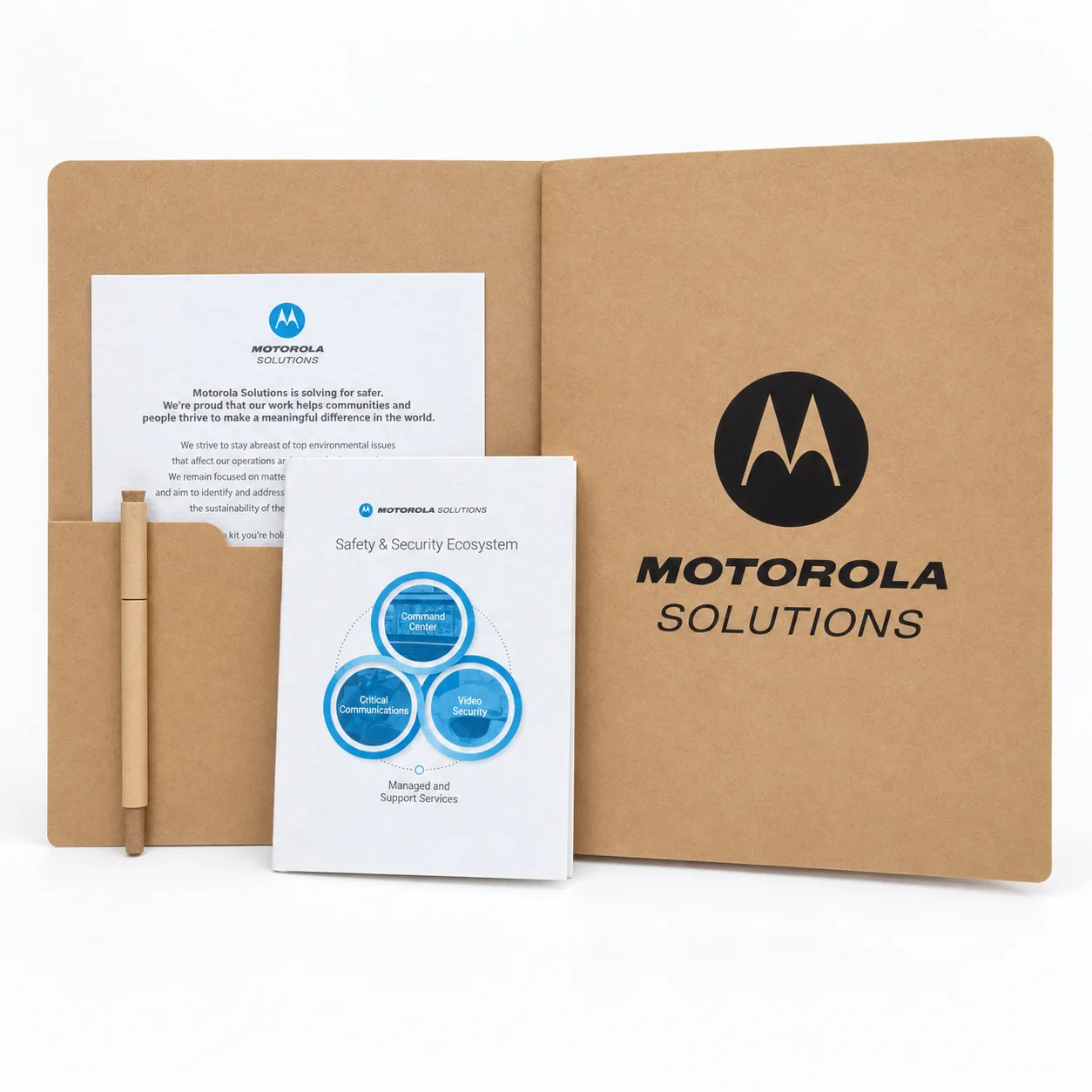 An open kraft folder with the client’s mark, holding a letter, a seed-paper booklet titled Safety and Security Ecosystem and a paper pen