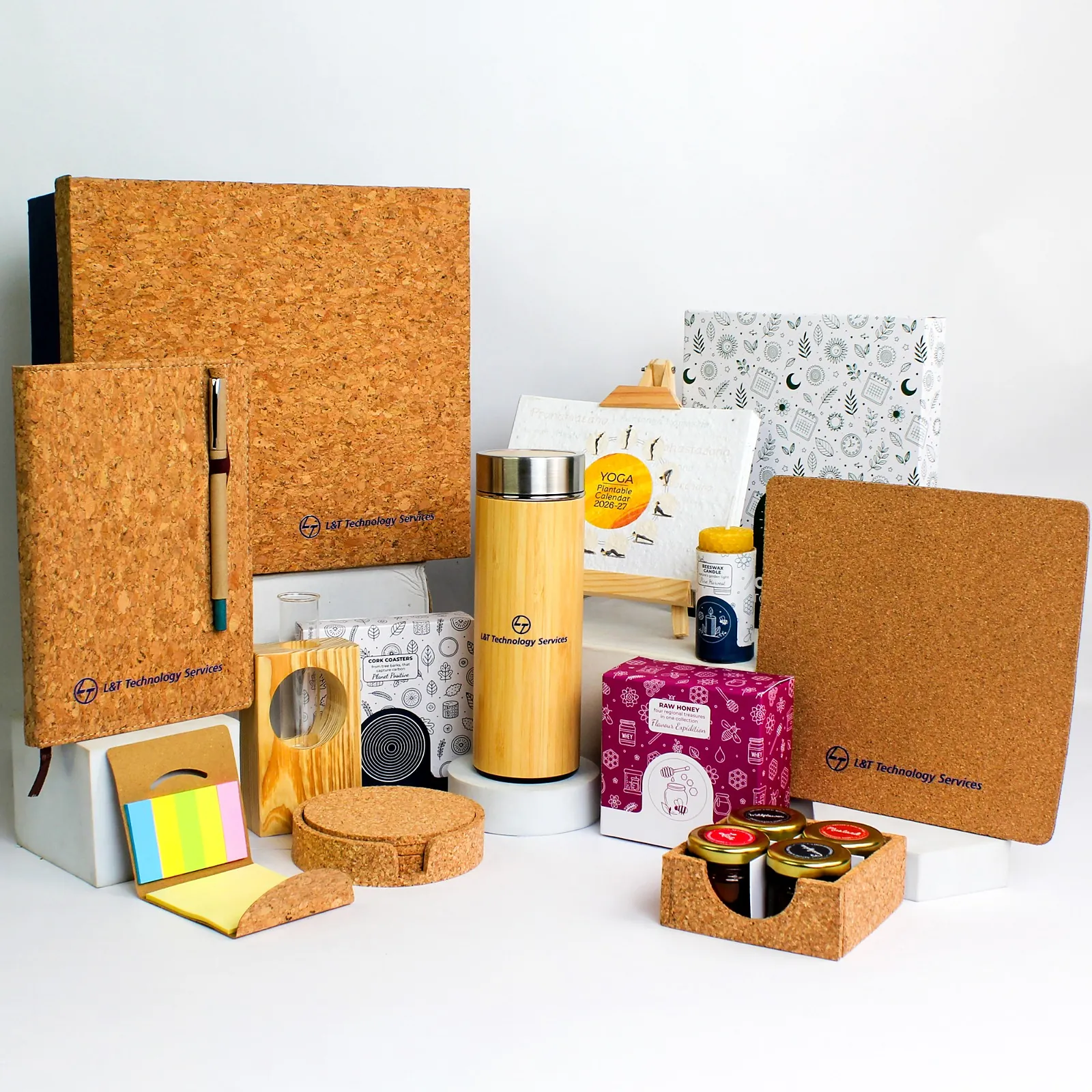 A cork desk kit: cork-bound notebook, bamboo flask, cork coasters, sticky notes and a small box, each with the client’s mark