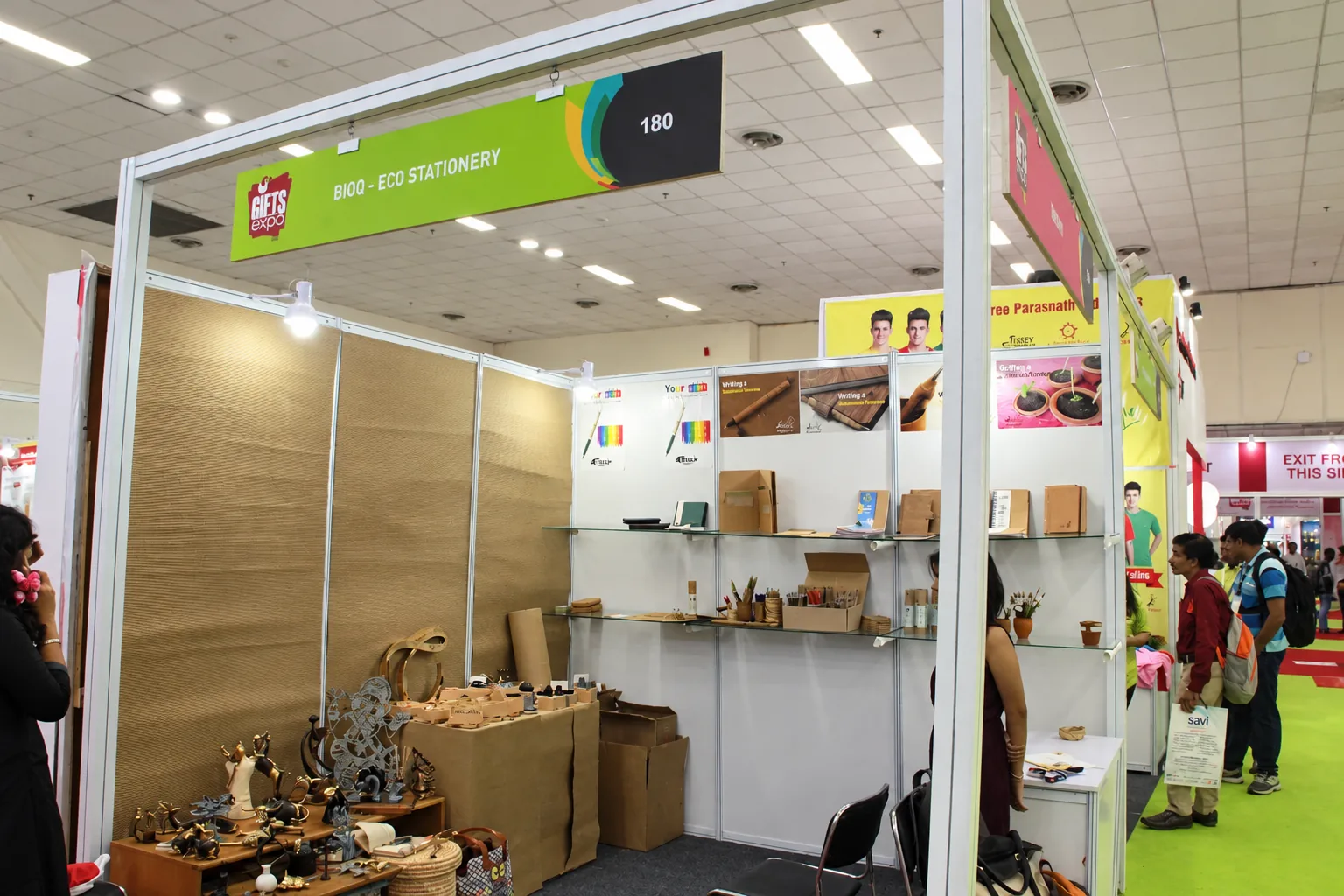 A small first stall with plain panels, shelves of notebooks and pens in tubes