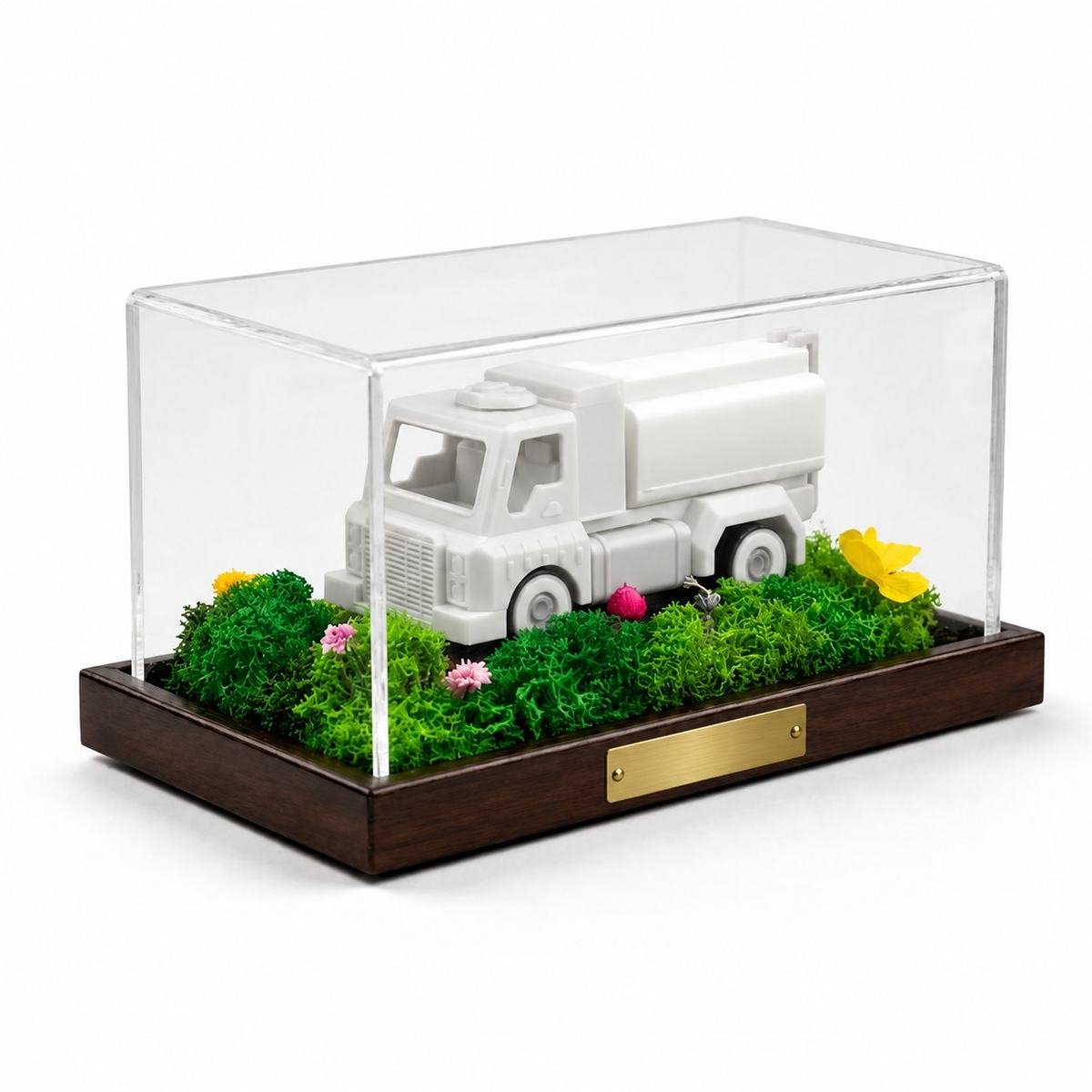 A plain white model truck in a moss landscape under a clear case