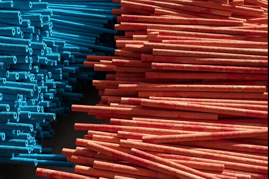 Stacks of rolled paper pencil bodies, blue and orange
