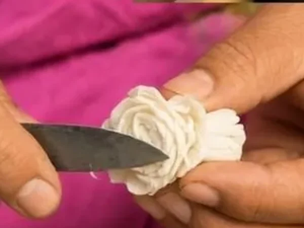 A knife slicing a sola pith flower