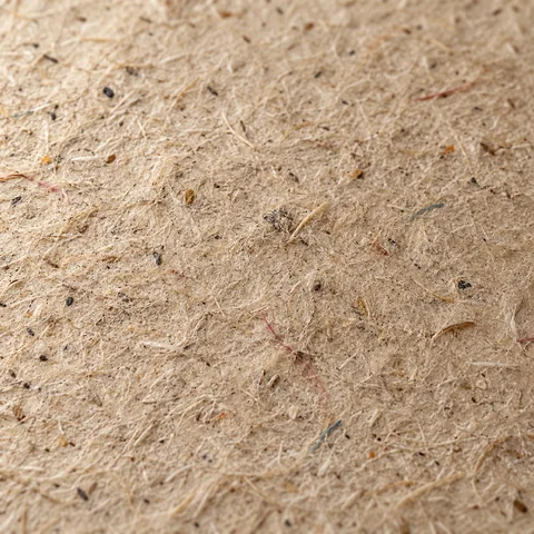 Recycled paper, close up: short fibres and flecks of pulp