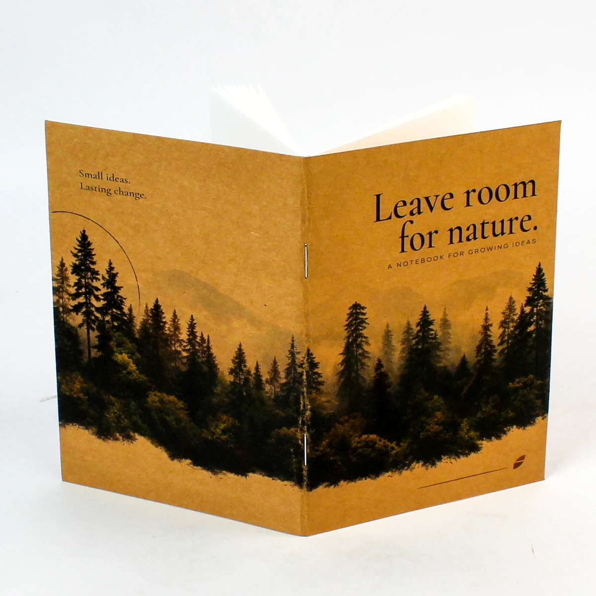 The kraft notebook cover opened flat, with forest artwork across the front and back